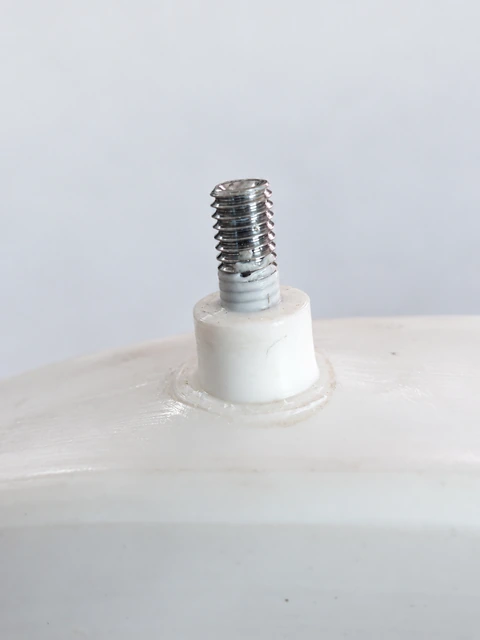 Close-up of a threaded metal air valve bonded to a white inflatable seal.